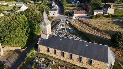 Église de village et son cimetière, vus du ciel en lumière rasante.