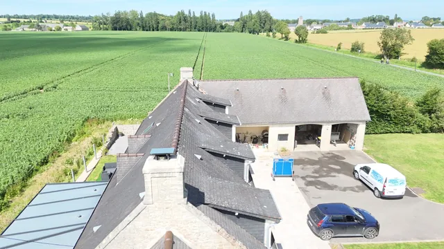 Longère normande en ardoise photographiée du ciel, en bordure de champ.