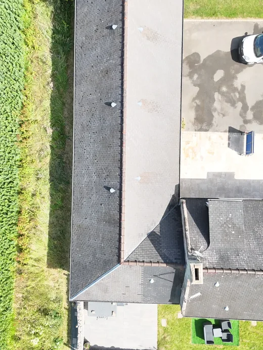 Vue verticale de la toiture en ardoise de la longère, sur toute sa longueur.