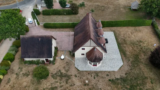 Autre angle aérien du même manoir, montrant les tourelles et le jardin.