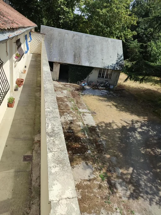 Vue plongeante depuis la nacelle, le long de la gouttière, sur la cour en contrebas.